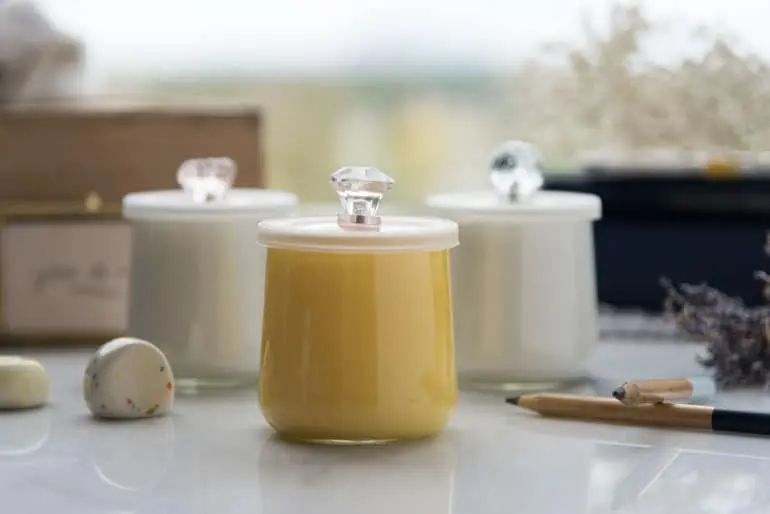 Three Oui by Yoplait yogurt jars painted and given lids with crystal handles.