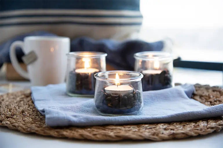 Three small Oui by Yoplait yogurt jars used as tea lights.