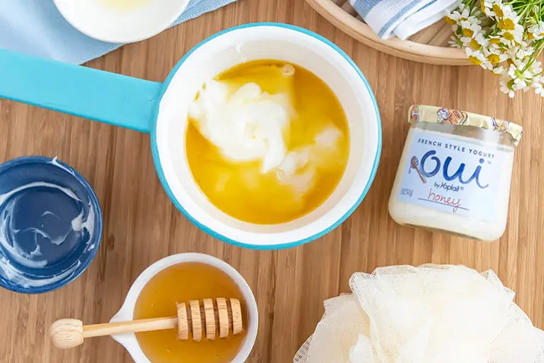 Honey and Oui by Yoplait yogurt combined into a cup with the two ingredients sitting next to the cup.